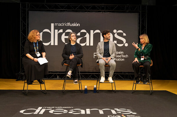Mesa redonda en Madrid Fusión con cuatro ponentes sentados, dialogando sobre salud en la cocina, con el cartel “dreams. Madrid Fusión” de fondo