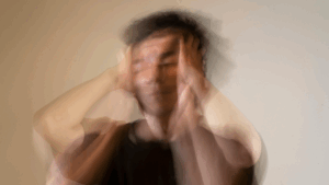 Hombre desenfocado llevándose las manos a la cabeza, representando estrés o agotamiento emocional