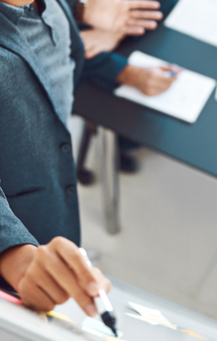 Profesional trabajando y tomando notas durante una reunión, simbolizando foco y presencia en la toma de decisiones.