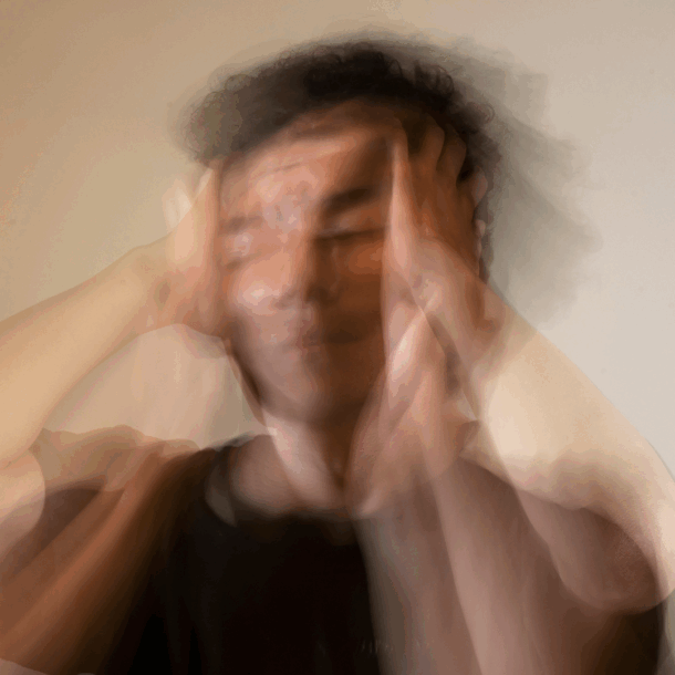 Hombre desenfocado llevándose las manos a la cabeza, representando estrés o agotamiento emocional