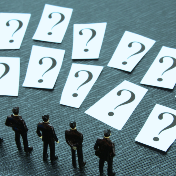 Figuras en miniatura observan múltiples tarjetas con signos de interrogación, simbolizando la reflexión, el pensamiento crítico y la búsqueda de respuestas a través de preguntas poderosas.