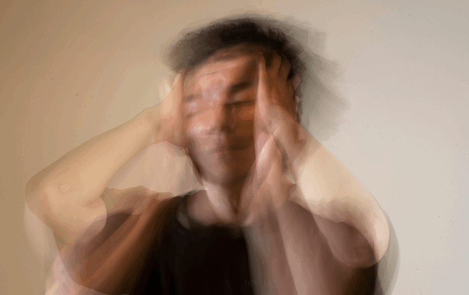 Hombre desenfocado llevándose las manos a la cabeza, representando estrés o agotamiento emocional