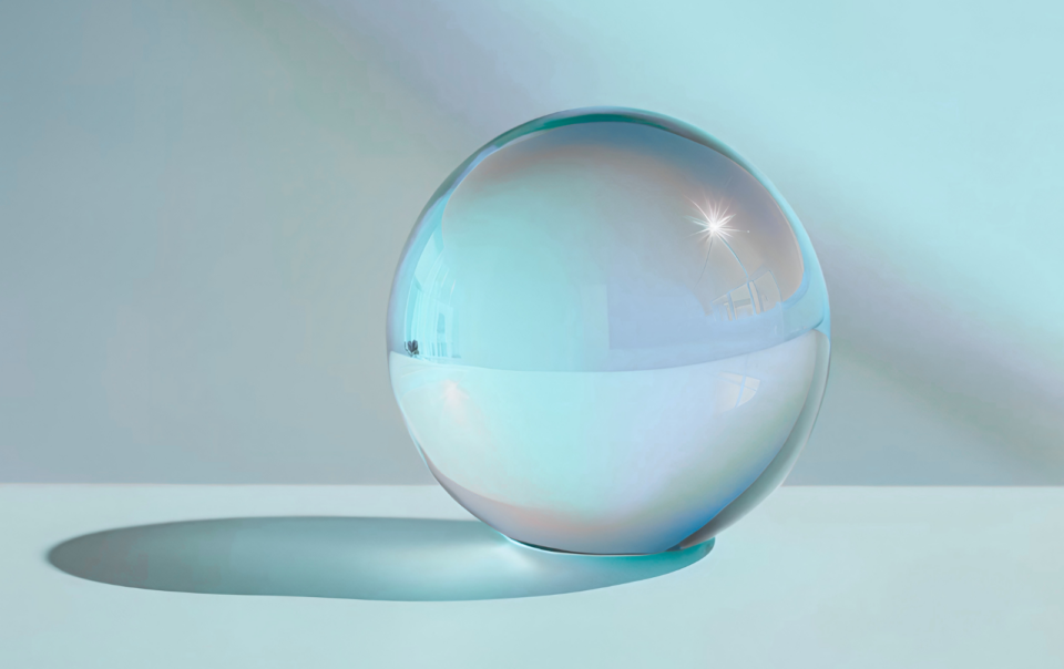 Esfera de cristal sobre una superficie lisa que simboliza la reflexión, la transparencia y el criterio ético en el uso de la inteligencia artificial.