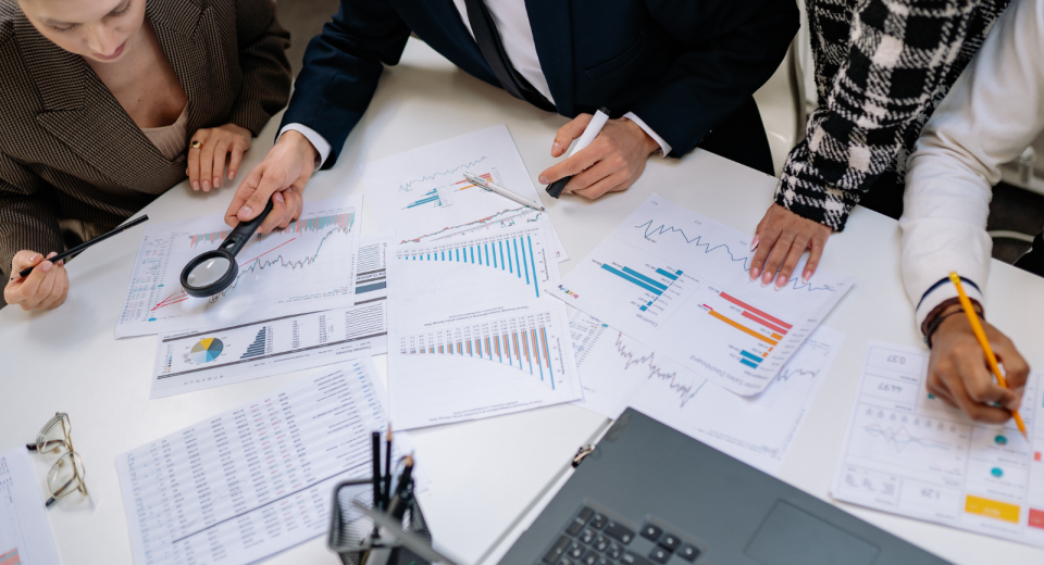 Equipo profesional analizando gráficos y datos en una reunión de trabajo, simbolizando la productividad orientada a resultados.
